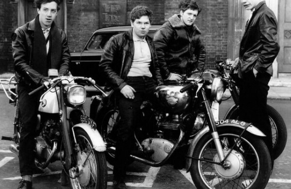 Des bottes de motos, un blouson de cuir noir avec un aigle sur le dos